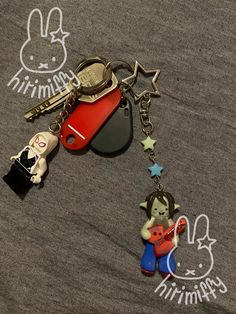 the key chain is attached to an animal shaped bag charm that has been placed on top of a t - shirt