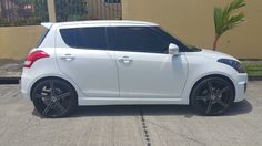 a small white car parked in front of a building