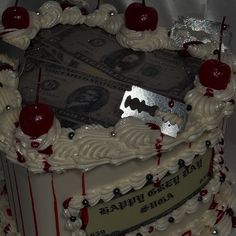 a cake with money and cherries on it