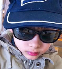 a young boy wearing sunglasses and a hat