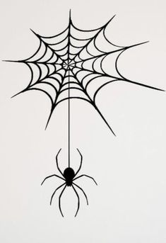 a spider web hanging from the ceiling in front of a white wall with black lines