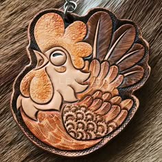 a brown and black animal with feathers on it's face is hanging from a chain