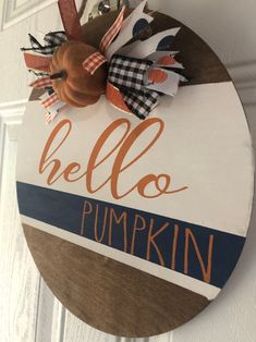 a wooden sign hanging on the side of a door that says hello pumpkins