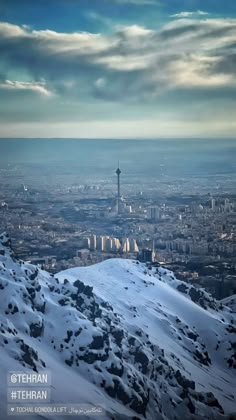 the view from top of a mountain looking down on a city and mountains in the distance