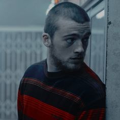 a man standing in front of a mirror with his head turned to the side and looking at something