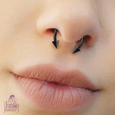 a woman's nose with two black arrows sticking out of it