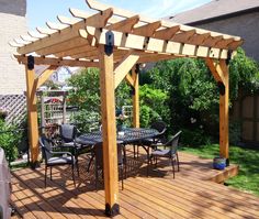 a wooden patio with an outdoor dining table and chairs under a pergolated roof