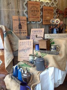 there are many items on the table in this shop display that is covered with burlap