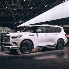 a white infiniti suv on display at an auto show
