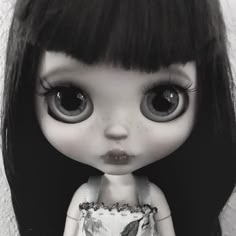 a black and white photo of a doll with big eyes