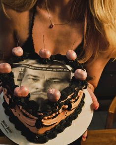a woman holding up a cake with an image on it