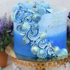 there is a blue cake with flowers on it