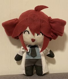a stuffed animal with red hair wearing a tie and coat on top of a table