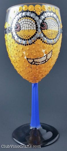 a yellow and blue wine glass sitting on top of a table