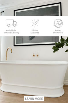 a white bath tub sitting in a bathroom next to a plant and framed pictures on the wall