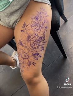 a woman's thigh with flowers on it and the bottom half of her leg