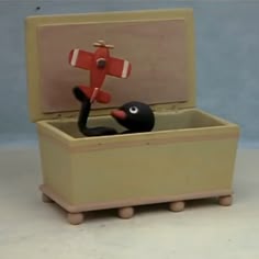 an open suitcase with a toy bird inside