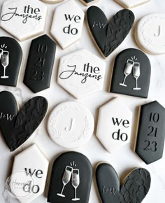 cookies decorated with black and white icing are arranged in the shape of heart, wine glasses, champagne glass, we do