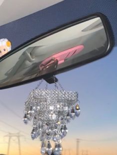 the rear view mirror on a car is decorated with crystal chandelier hanging from it's side