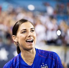a female tennis player is smiling and looking to the side