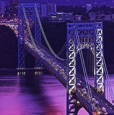 an aerial view of the new york city bridge at night with traffic on it's sides