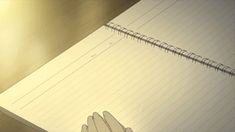 a hand holding a pen on top of a notebook