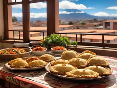 several plates of food on a table in front of a window