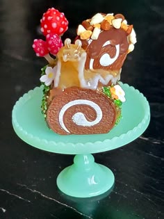 there is a small cake that looks like a snail on top of a green plate