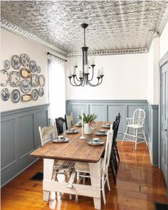 an instagram photo of a dining room with blue painted walls and wood flooring