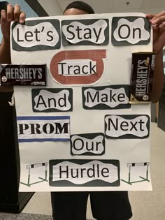 a person holding up a sign that says let's stay on track and make prom our huddle