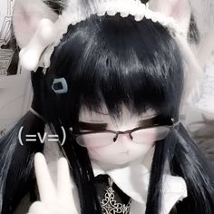 a girl with long black hair and glasses making the peace sign