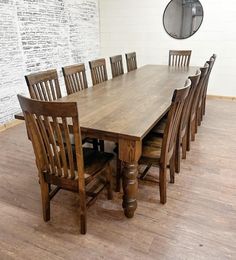 a wooden table and chairs in a room with white brick wall behind it, along with hardwood flooring