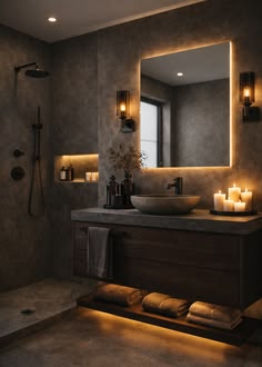 a bathroom with a sink, mirror and candles on the counter top in front of it
