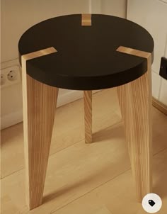 a small black table sitting on top of a hard wood floor next to a door
