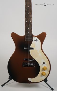 an electric guitar with a brown body and white neck