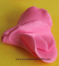 a pink pastry sitting on top of a yellow table