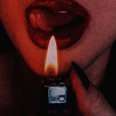 a woman holding a lighter in front of her face