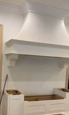 a kitchen with white cabinets and an oven hood