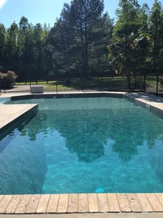 an empty swimming pool surrounded by trees