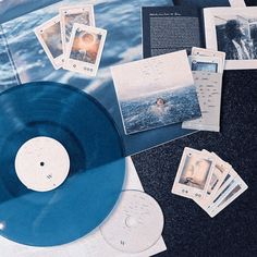 a blue vinyl record sitting on top of a table next to other cds and papers