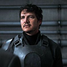 a man in a black suit and helmet looking at the camera with an intense look on his face
