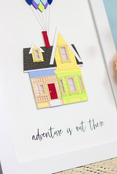 there is a card with a house and balloons on it