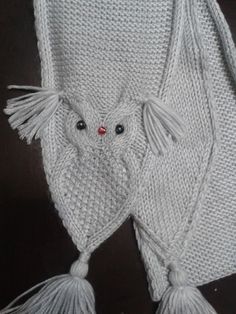 a white knitted owl with tassels on it