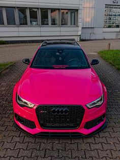 a pink car parked in front of a building