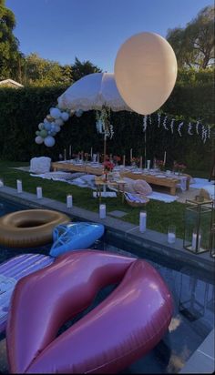 an inflatable balloon floating over a pool with other floats and decorations around it