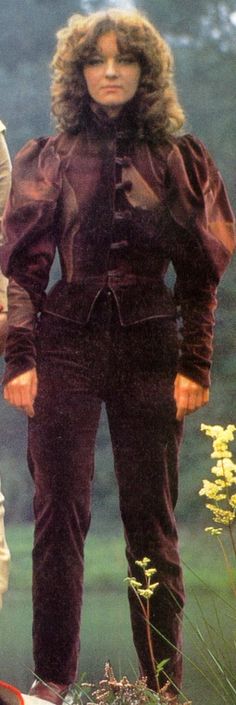 two women standing next to each other in the grass