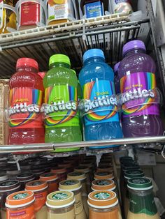 there are many different kinds of juices on the shelf in this grocery store,