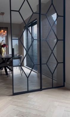 an open glass door in the middle of a dining room with chairs and a table
