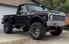 a black truck parked in front of a garage