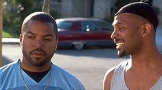 two men standing next to each other in the street